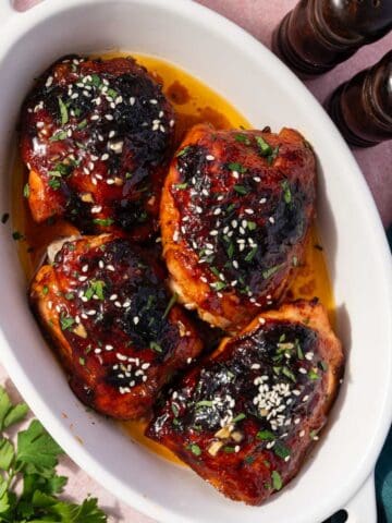 Oven baked honey garlic chicken thighs with sticky glaze in a baking dish