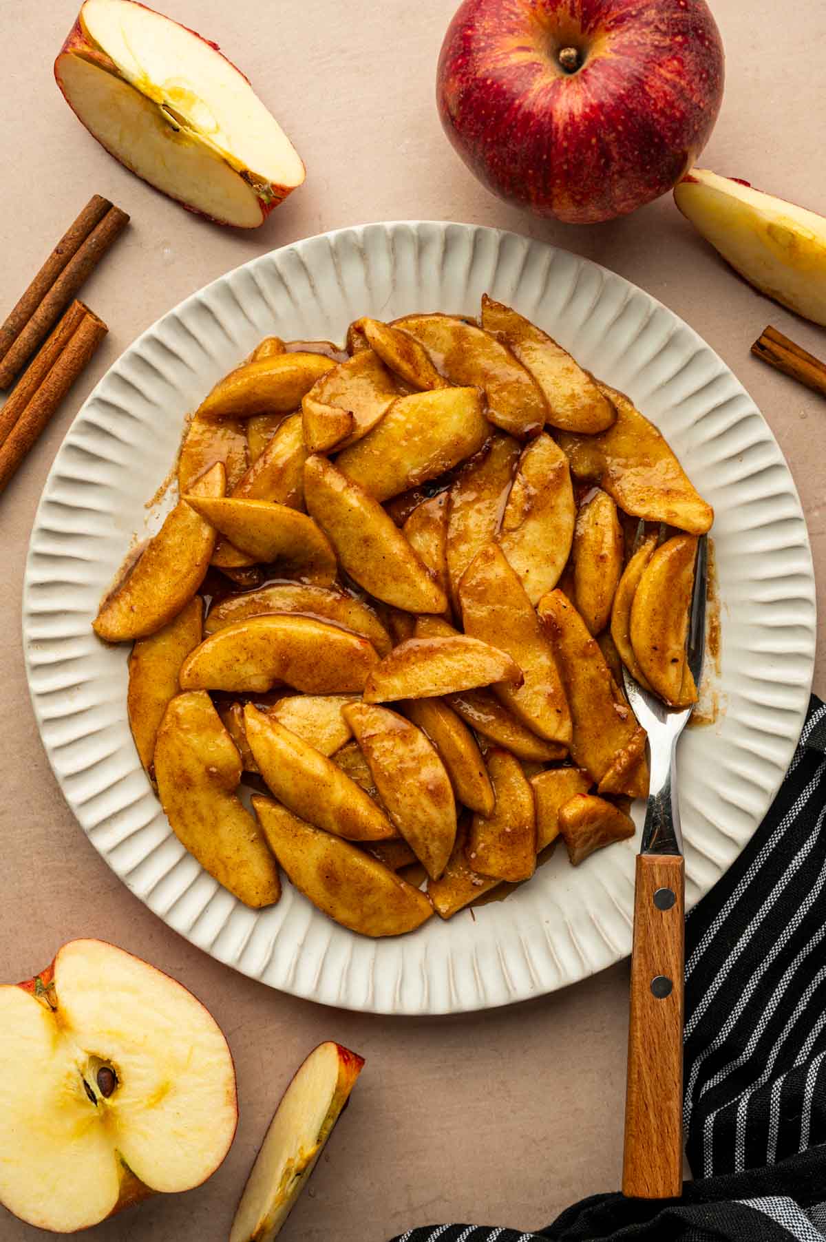 Caramelized air fryer cinnamon apples ready to serve with a fork
