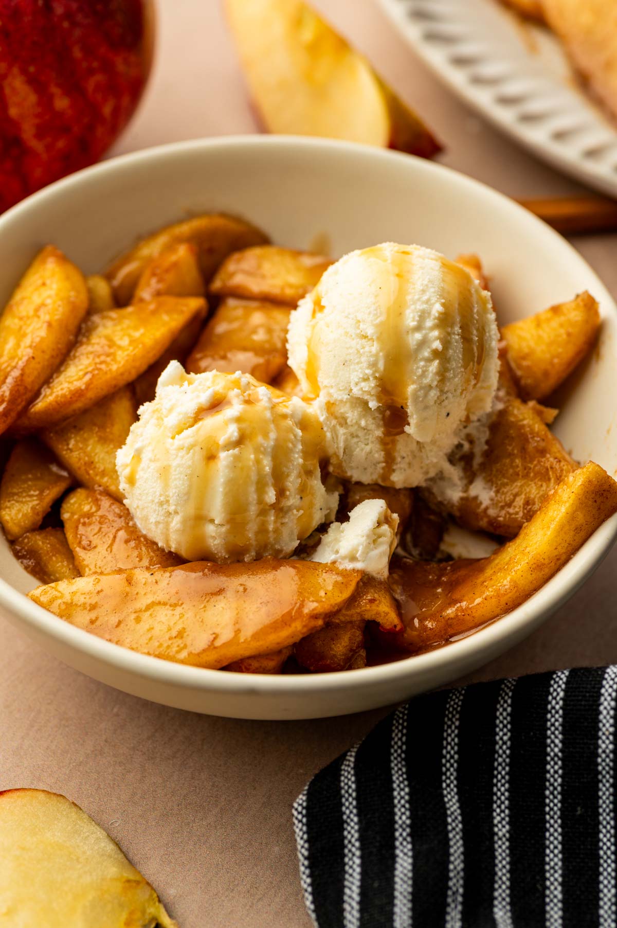 Air fryer apple being served in a bowl with ice cream