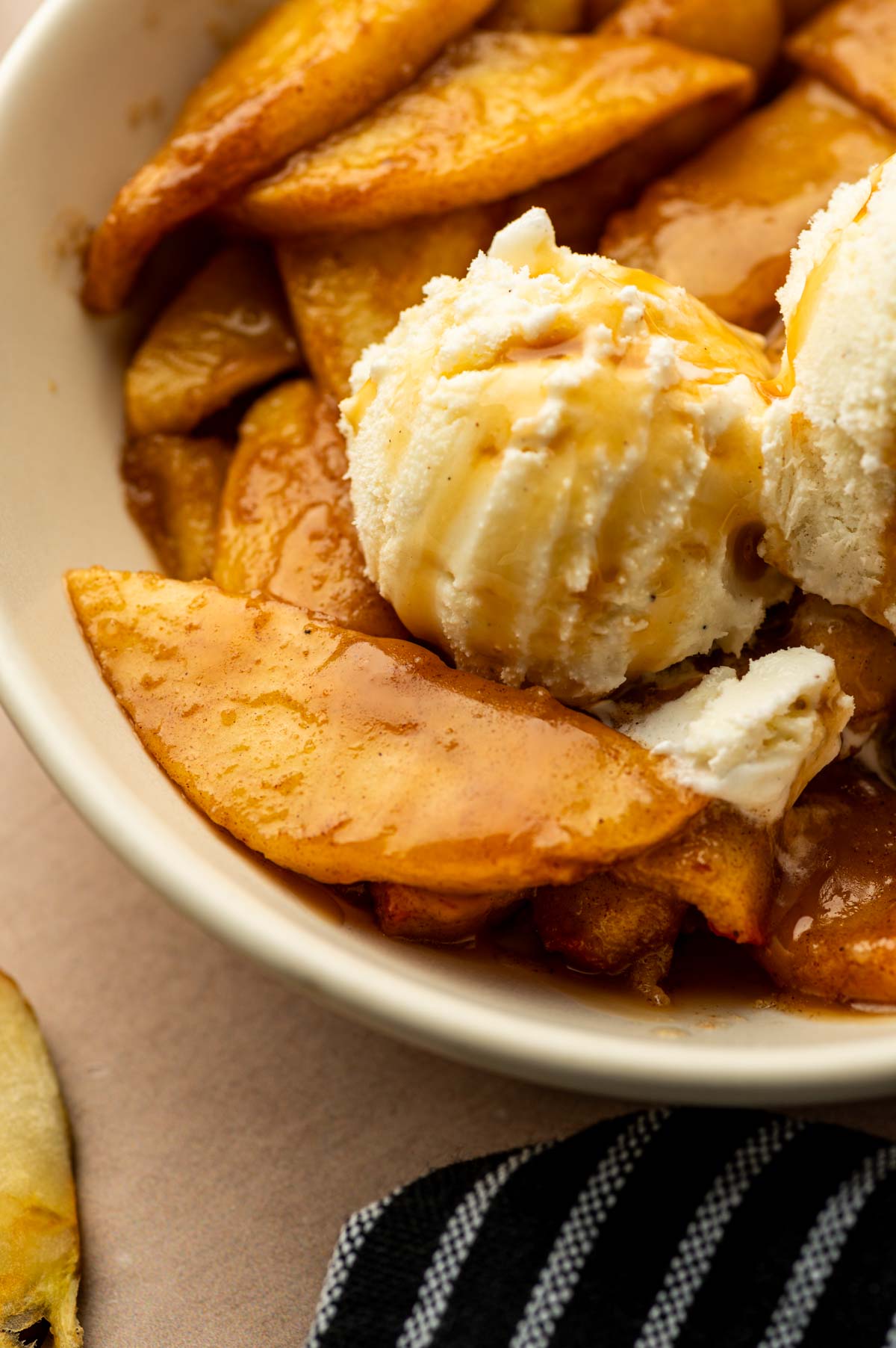 Close up shot of caramelized apple slices with ice cream.