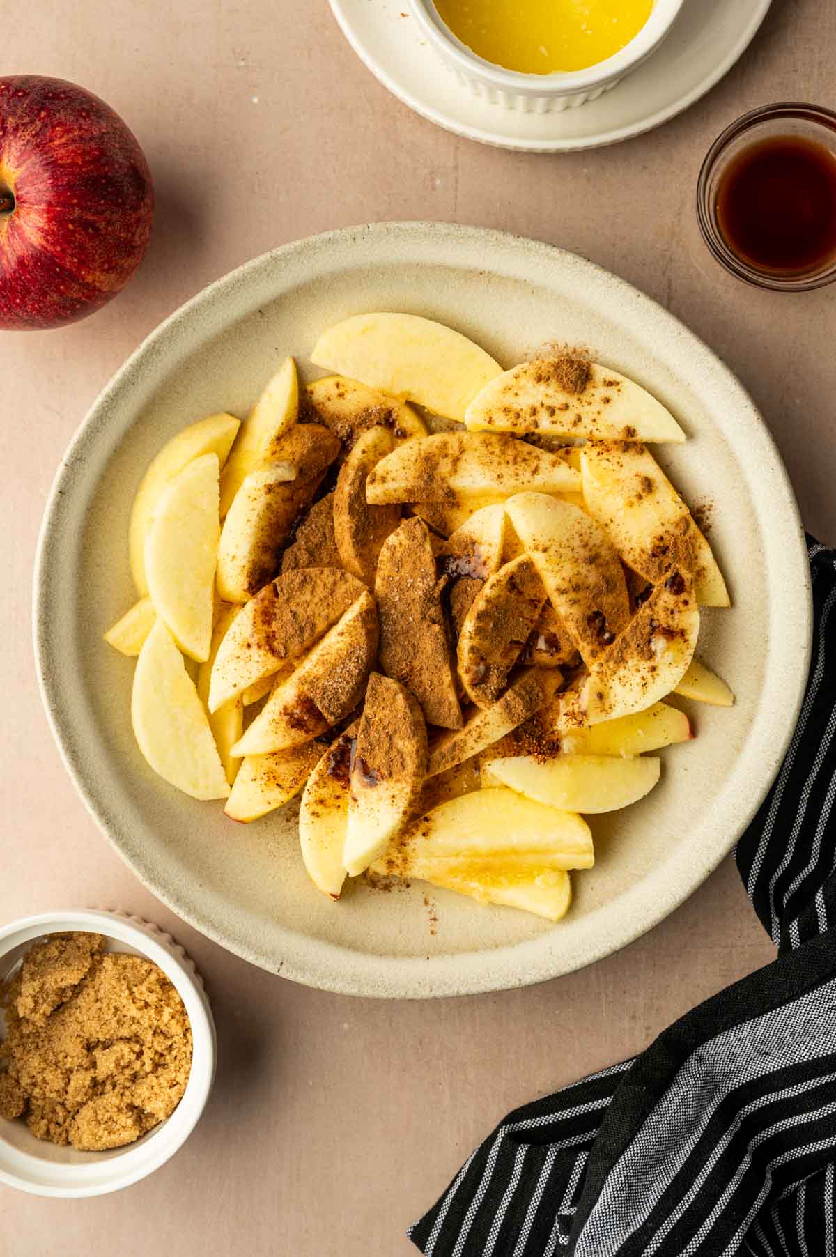 Seasonings being added to the apple slices.