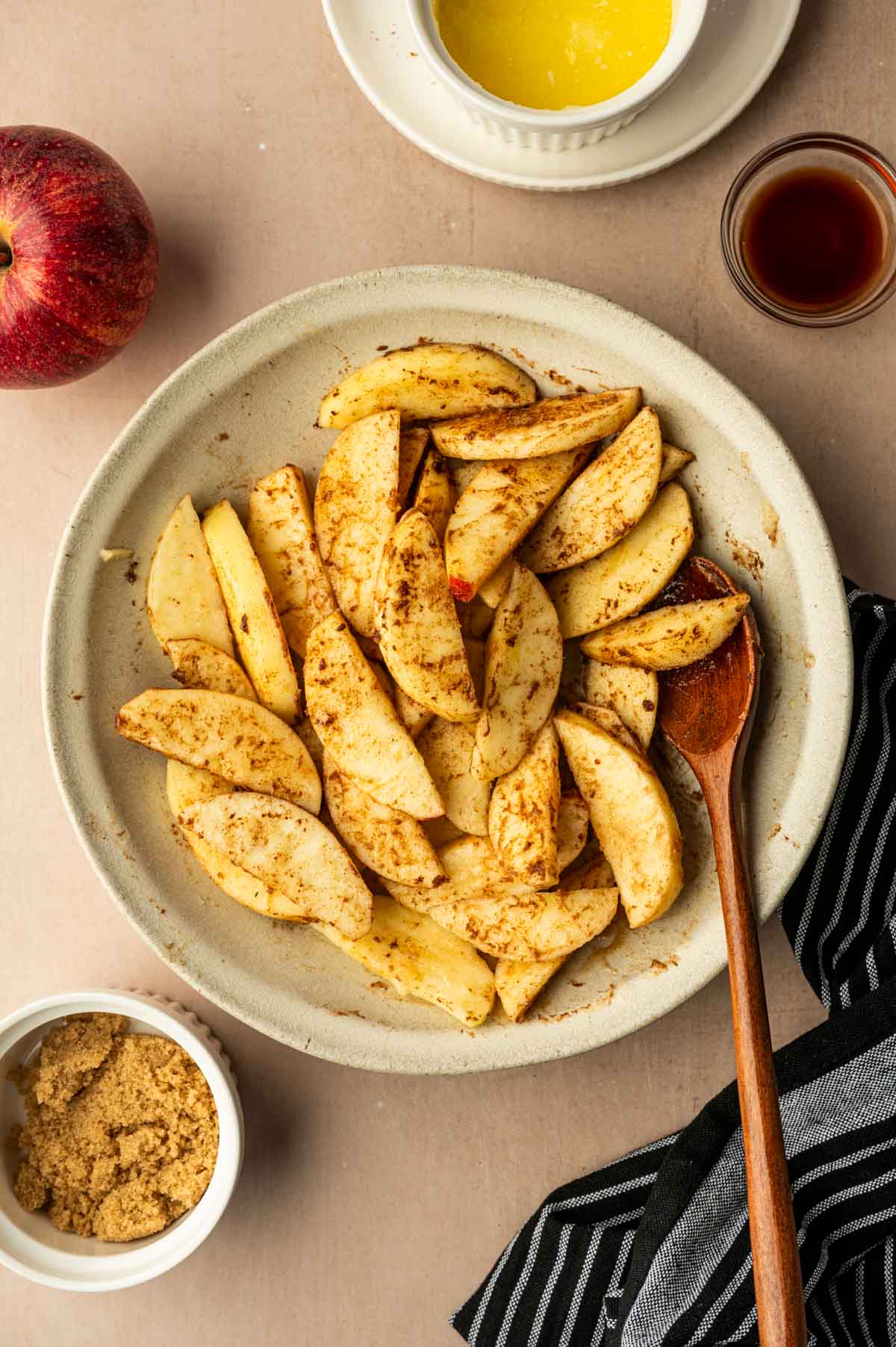 Cinnamon mixture being tossed to the apple slices