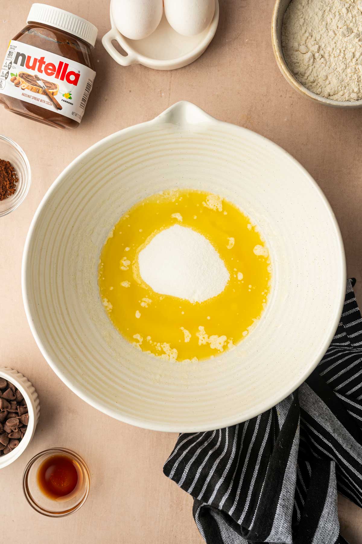 Melted butter and sugar placed in a bowl ready to whisk for making nutella brownies.