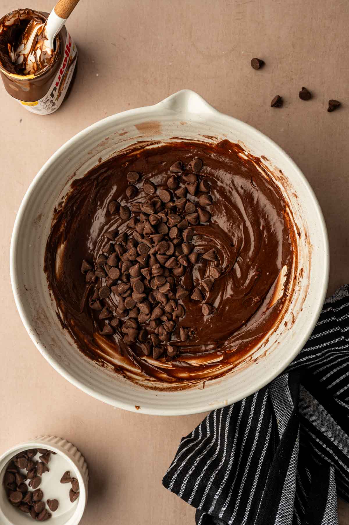 Chocolate chips being added to the nutella brownie batter.