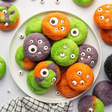 Purple, orange, and green monster cookies with edible eyeballs for Halloween
