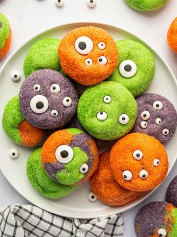 Purple, orange, and green monster cookies with edible eyeballs for Halloween
