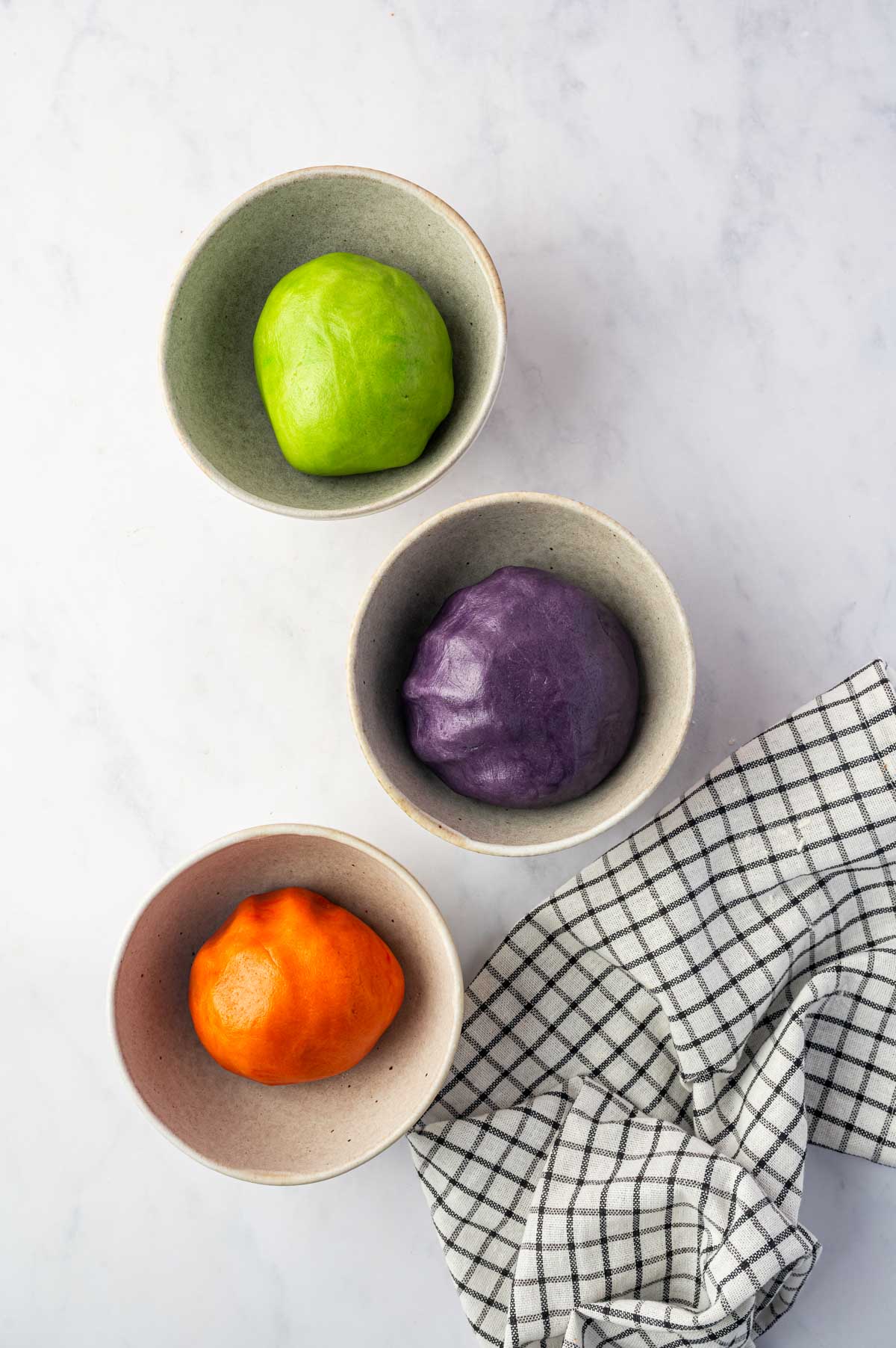 Halloween colored cookie dough placed in bowls