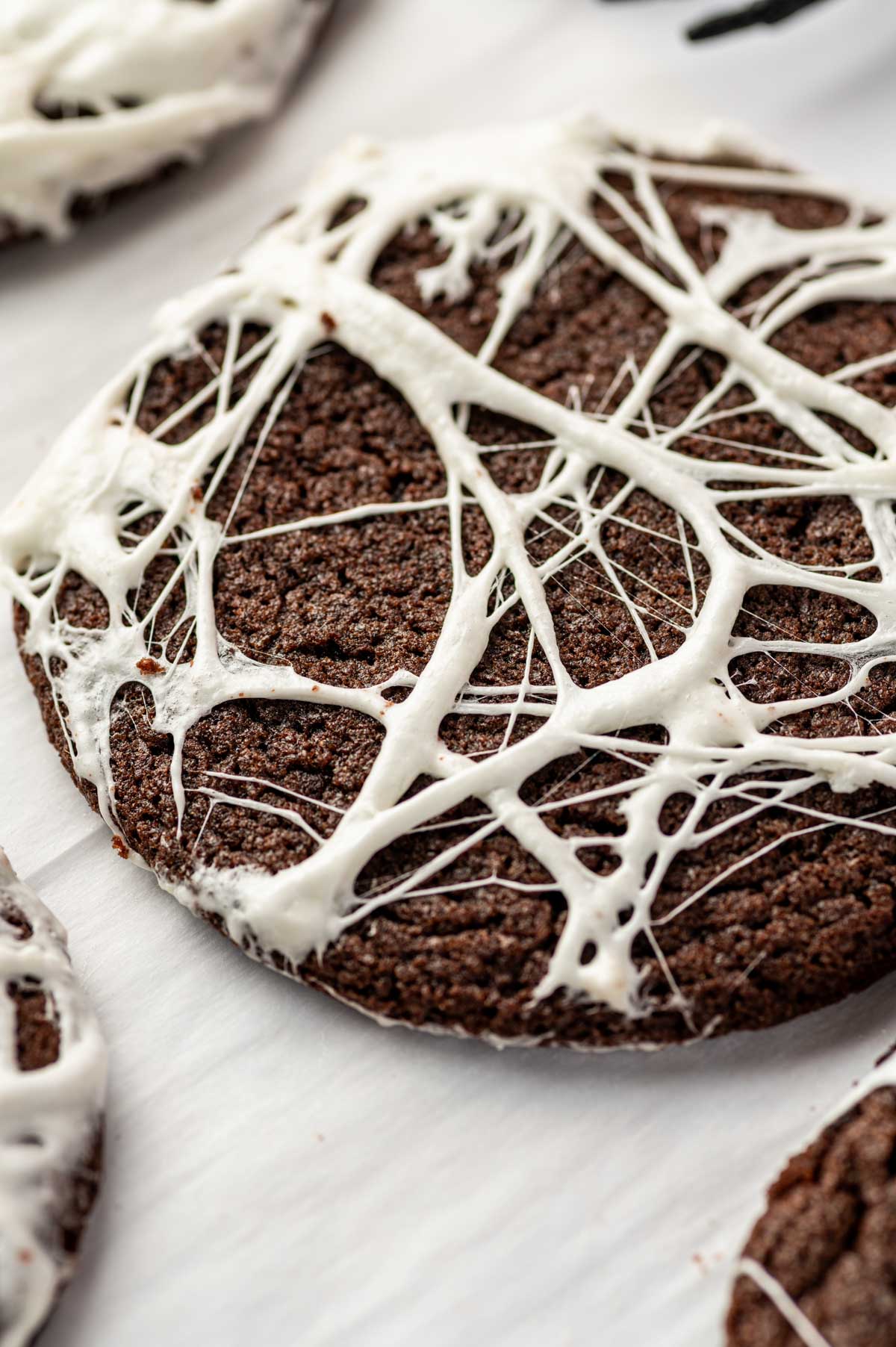 Close-up of chocolate Spider Web Cookies decorated with melted marshmallow